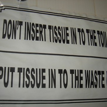 The sign says: "Don't insert tissue into the toilet. Put tissue into the waste box."