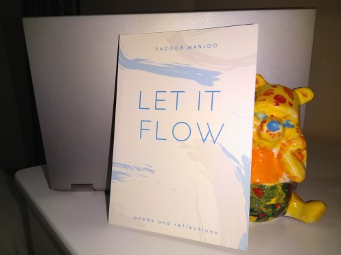 An painted statue of WInnie the Pooh behind a book titled 