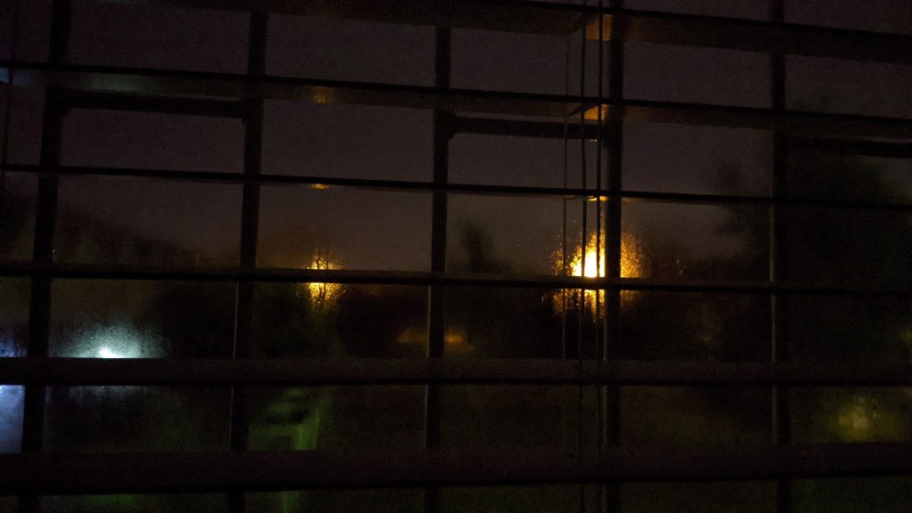 Street lights through blinds at night.